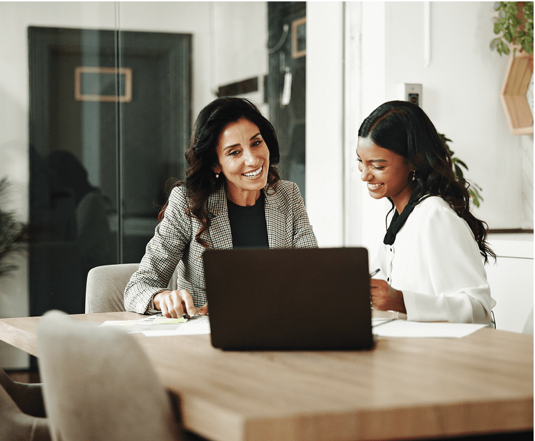 Colleagues discussing work at a laptop