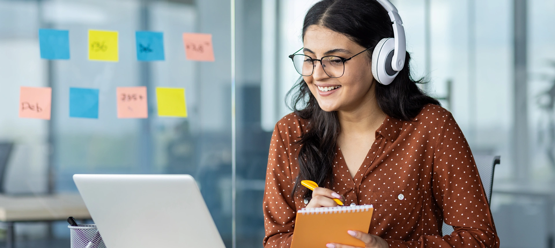 Woman studying with headphones and laptop