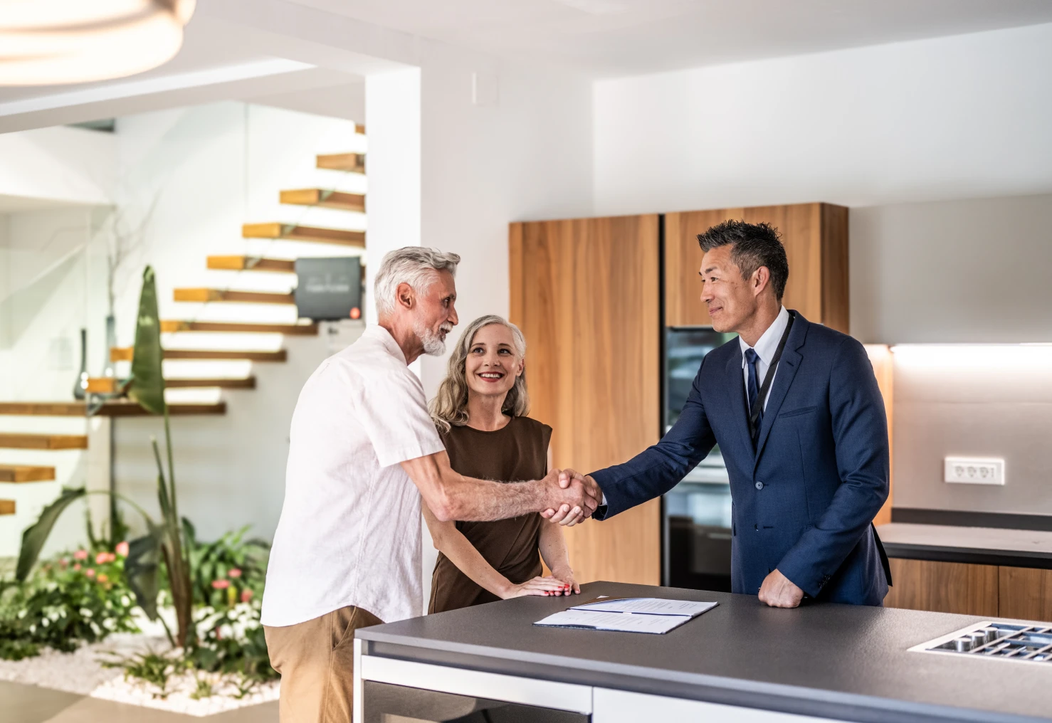 Couple shaking hands in modern kitchen