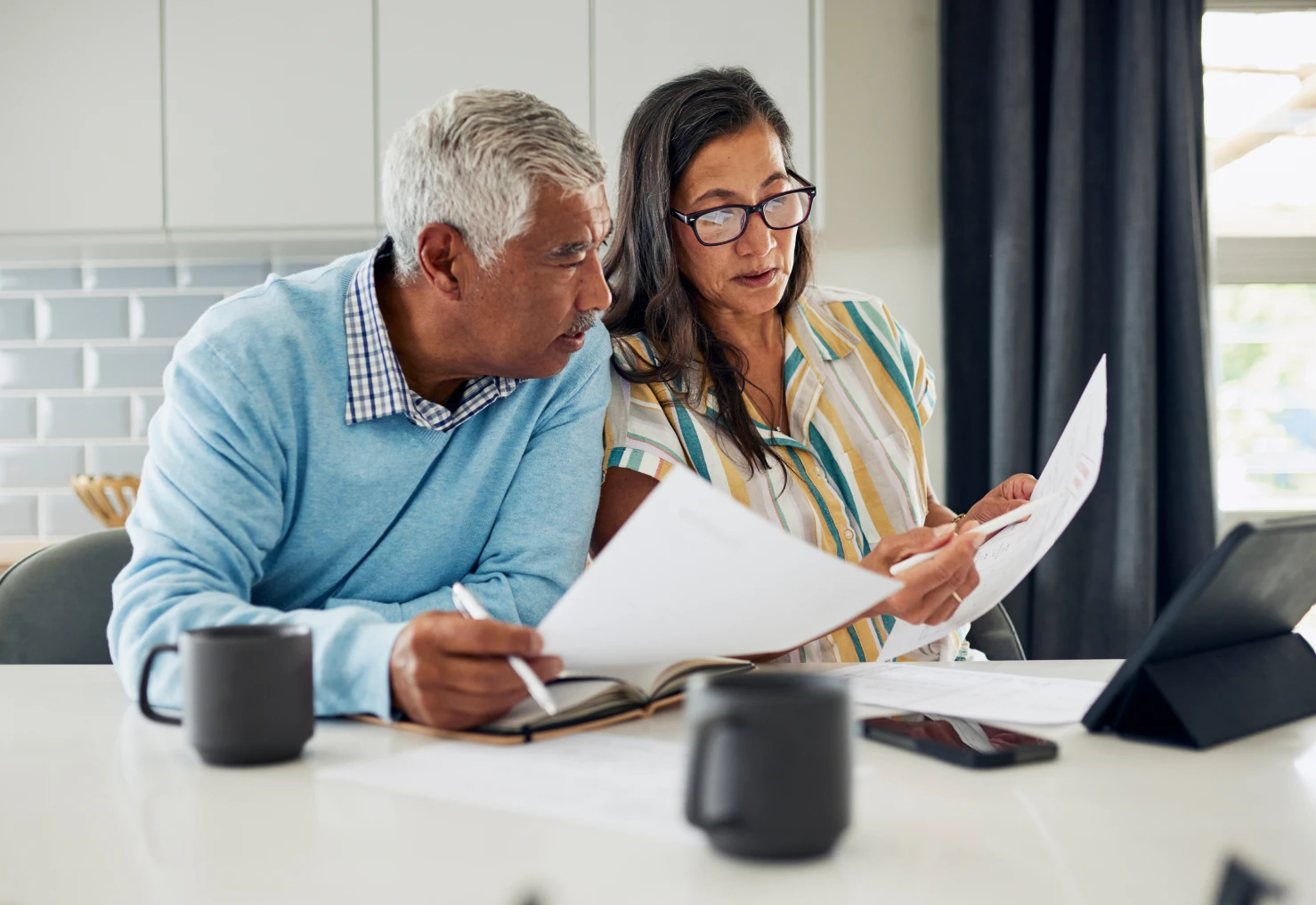 Pair examining financial documents at home